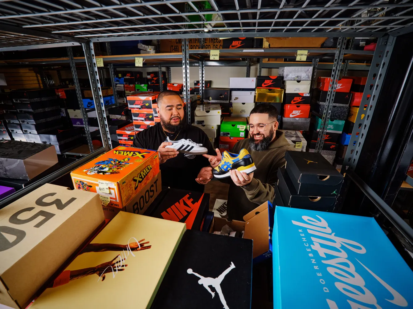 Two ebay sellers looking at shoes amongst shoeboxes