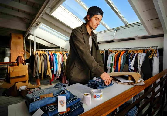 A man packing vintage clothes for shipping